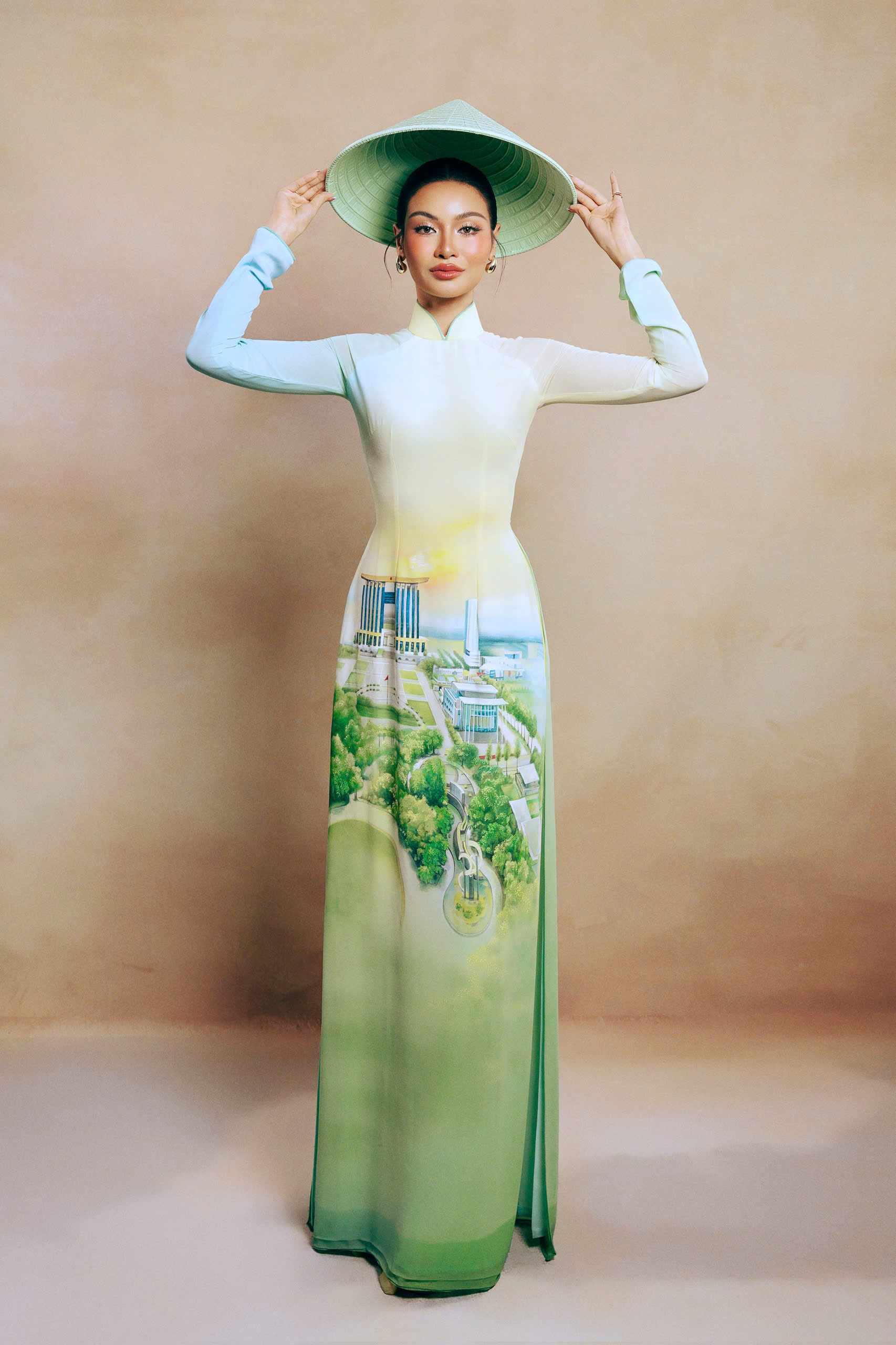 Á hậu Miss Cosmo 2024 - Hoa hậu Hoàn vũ Quốc tế 2024 Mook Karnruethai Tassabut nổi bật với chiếc áo dài tông xanh, vẽ cảnh trung tâm hành chính của Bình Dương trước đây. Từ tháng 7/2025, Bình Dương cùng Bà Rịa – Vũng Tàu sáp nhập vào TPHCM, tạo nên thành phố với tổng diện tích 6.772,6 km².