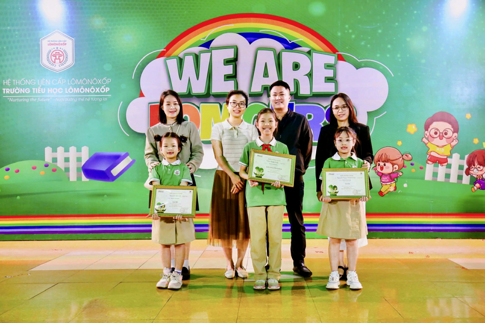 Từ trái sang: Nguyễn Hà Chi - giải Nhì, Trần Minh Anh - giải Khuyến khích, Nguyễn Ngọc Minh Châu - giải Ba và phụ huynh trong buổi trao giải - ẢNH: PHAN NGỌC