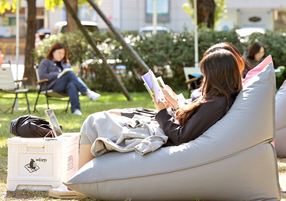 Người dân đọc sách tại công viên châu Á ở quận Songpa, phía nam Seoul, trong khuôn khổ chiến dịch thư viện ngoài trời của quận vào tháng 10/2025 - Nguồn ảnh: Yonhap 