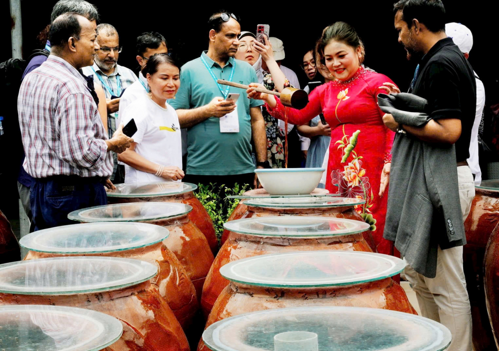Chị Nguyễn Thị Chiến (thứ hai từ phải qua) - Giám đốc Công ty TNHH Sản xuất - Thương mại và Dịch vụ Hati - giới thiệu nước mắm truyền thống cho du khách nước ngoài