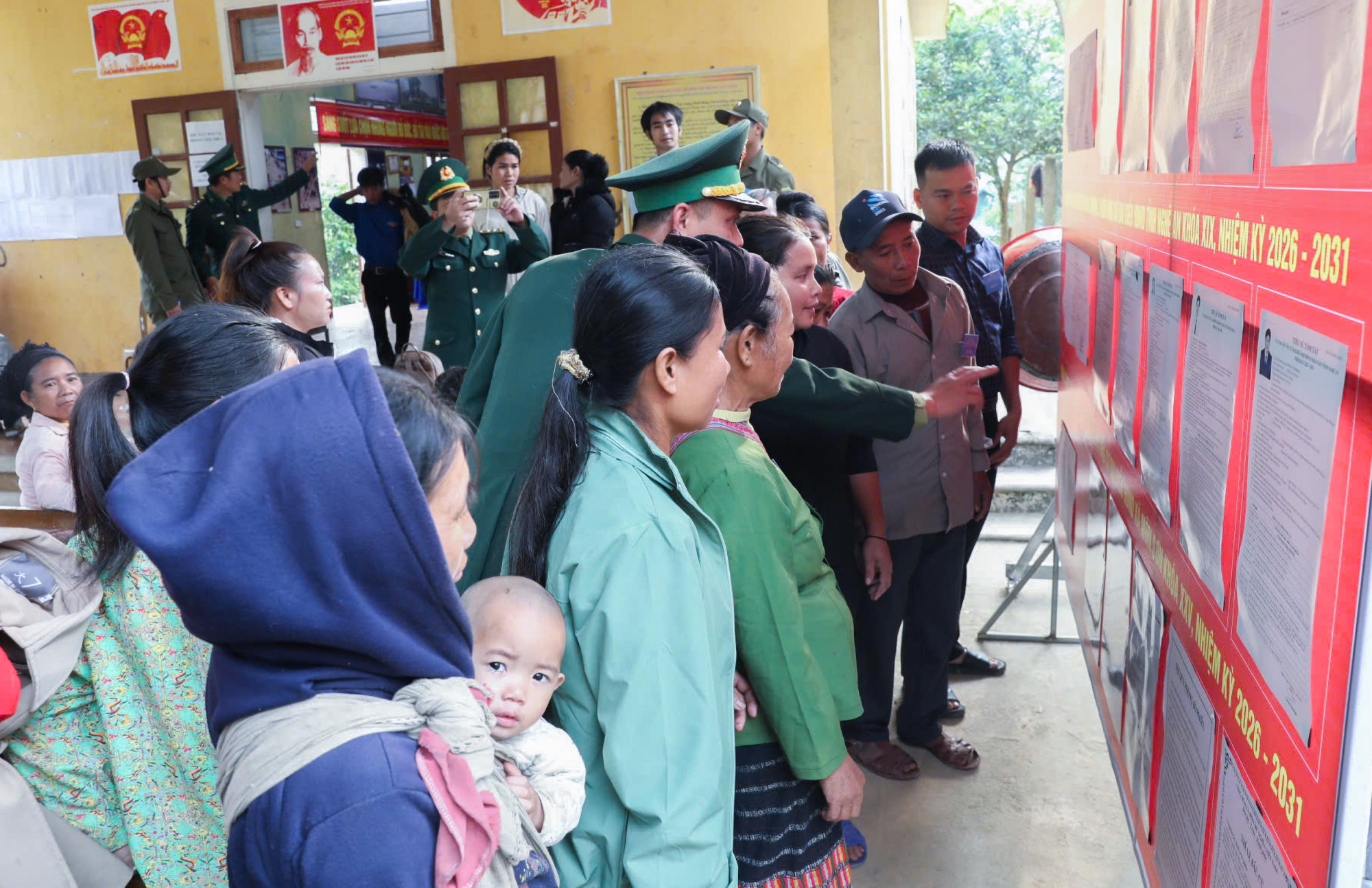 Bà con Đan Lai ở bản Cò Phạt xem lại danh sách niêm yết các ứng cử viên lần cuối trước khi đưa ra lựa chọn ứng cử viên - Ảnh: Khánh Trung