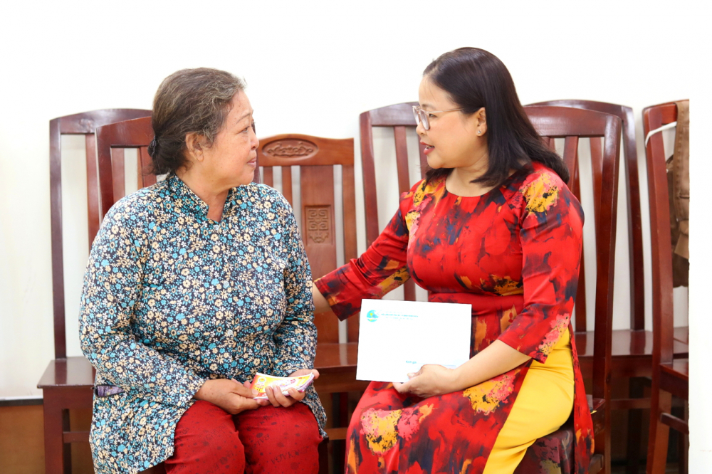 Bà Nguyễn Thị Minh Hậu (bìa phải) - Chủ tịch Hội LHPN phường Bình Hưng Hòa  - trao hỗ trợ cho bà Tống Bích Vân