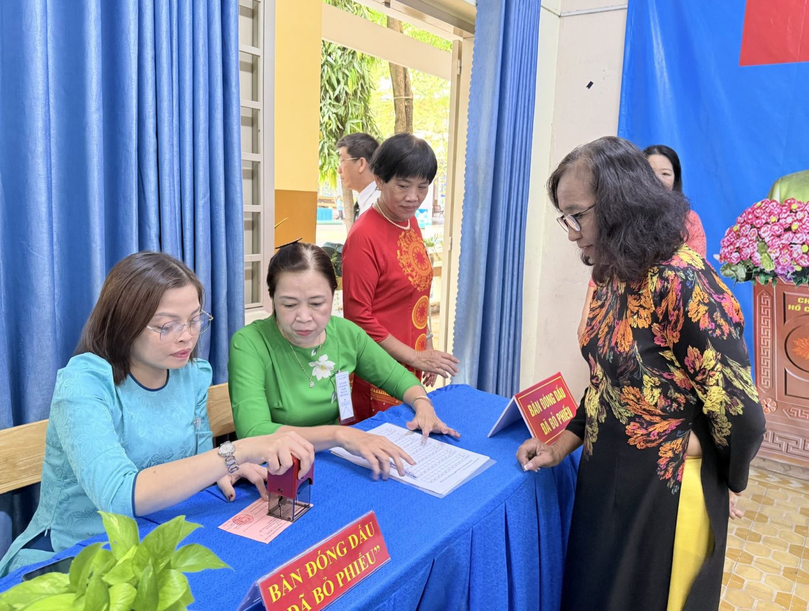 Cử tri Nguyễn Thị Súng (bìa phải) được hướng dẫn trước khi vào khu vực bỏ phiếu.