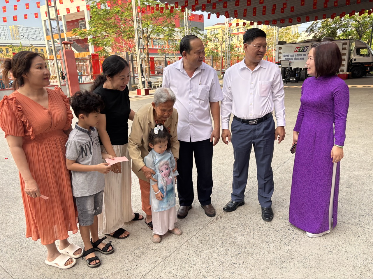 Gia đình cụ Huệ  được bà bà Phạm Hồng Minh được bầu giữ chức Bí thư Đảng ủy, Chủ tịch Hội đồng nhân dân (HĐND) phường Bình Phú (áo tím) thăm hỏi, trò chuyện