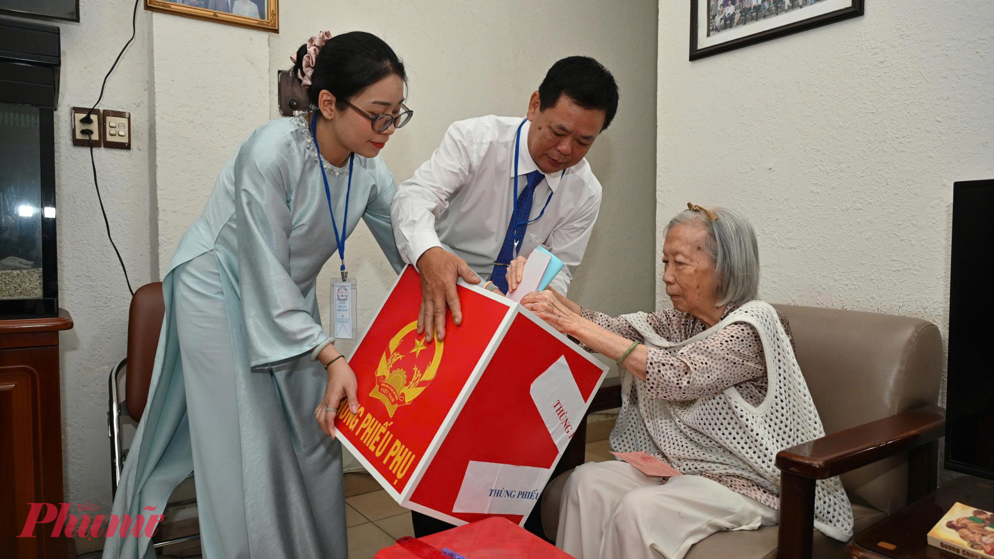 Trực tiếp: Người dân cả nước đi bỏ phiếu bầu cử Bà Dương Bạch Lan (70 tuổi), vì tuổi già sức yếu nên được đại diện tổ bầu cử hỗ trợ mang thùng phiếu đến tận tay để bà thực hiện quyền công dân của mình. Ảnh: Trang Thư