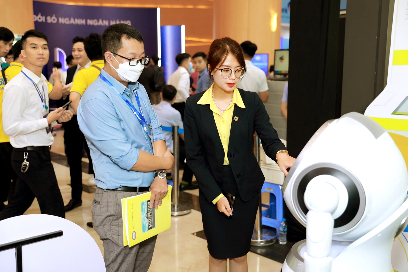 Nhân viên Ngân hàng thương mại cổ phần Nam Á (Nam A Bank) giới thiệu người máy OPBA tích hợp công nghệ AI tiên tiến để tư vấn sản phẩm, dịch vụ và hỗ trợ khách hàng