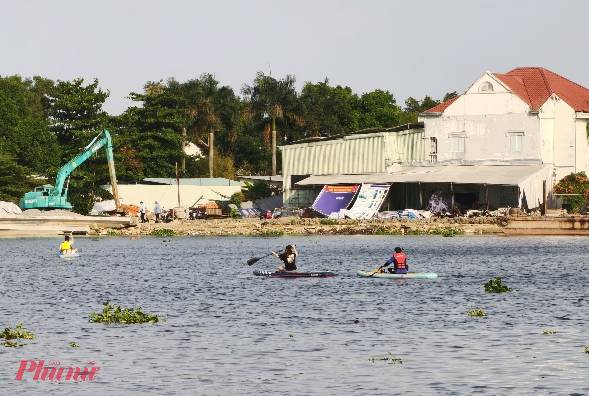 Nhóm bạn trẻ chèo SUP ra giữa sông, nơi luồng tàu lớn di chuyển - Ảnh: Nguyễn Văn