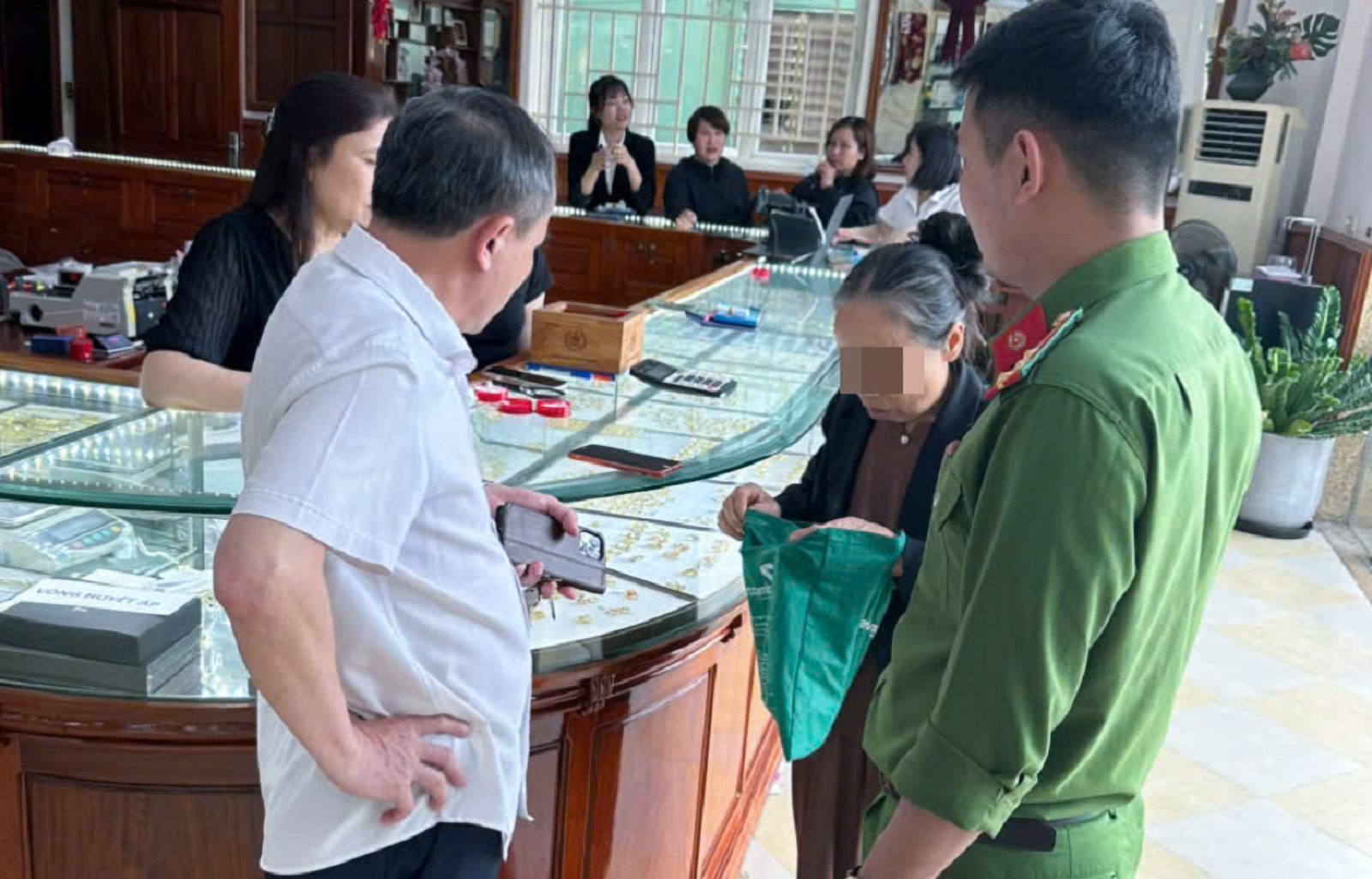 Lực lượng công an giải thích về hình thức lừa đảo và can ngăn bà H. bán vàng chuyển tiền cho kẻ lừa đảo - Ảnh công an cung cấp