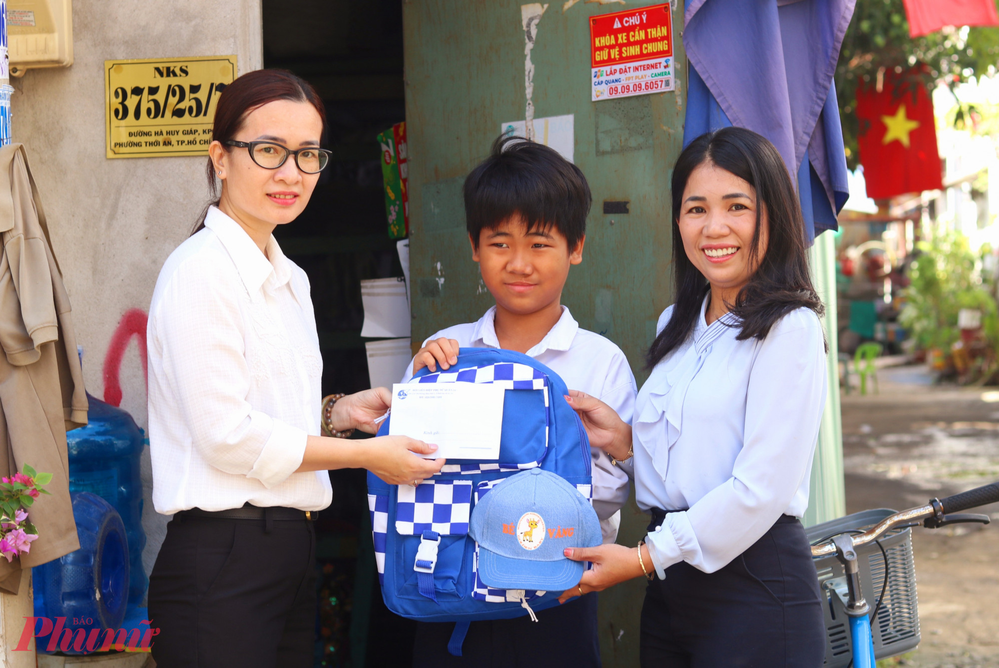 Bà Nguyễn Thị Thúy Vinh -  Phó chủ tịch Ủy ban MTTQ Việt Nam phường Thới An, Chủ tịch Hội LHPN phường (bìa trái) – trao quà và tiền hỗ trợ quý I/2026 cho em Nguyễn Đỗ Thanh Phong. Phong và em trai đều học lớp phổ cập. 2 anh em đi lượm ve chai bán kiếm tiền phụ mẹ. Mẹ của em dán hộp giấy thuê. 3 mẹ con mới chuyển đến phường Thới An sinh sống - Ảnh: Mẫn Nhi