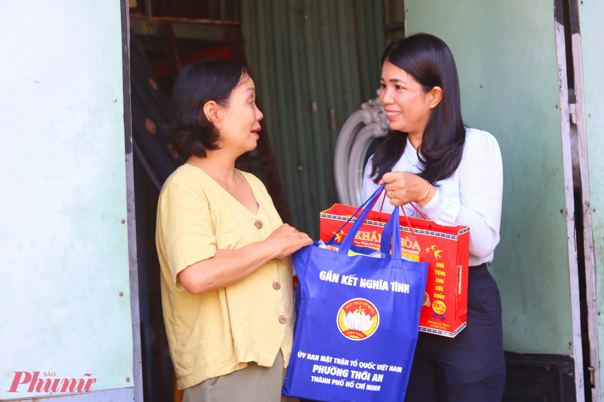 Bà Trần Ngọc Thu Sương - Ủy viên Ban thường vụ Hội LHPN phường Thới An (bìa phải) – trao quà cho chị Nguyễn Thị Lan, ở khu phố 46. Chị Lan bán vé số, nuôi 3 người con ăn học - Ảnh: Mẫn Nhi