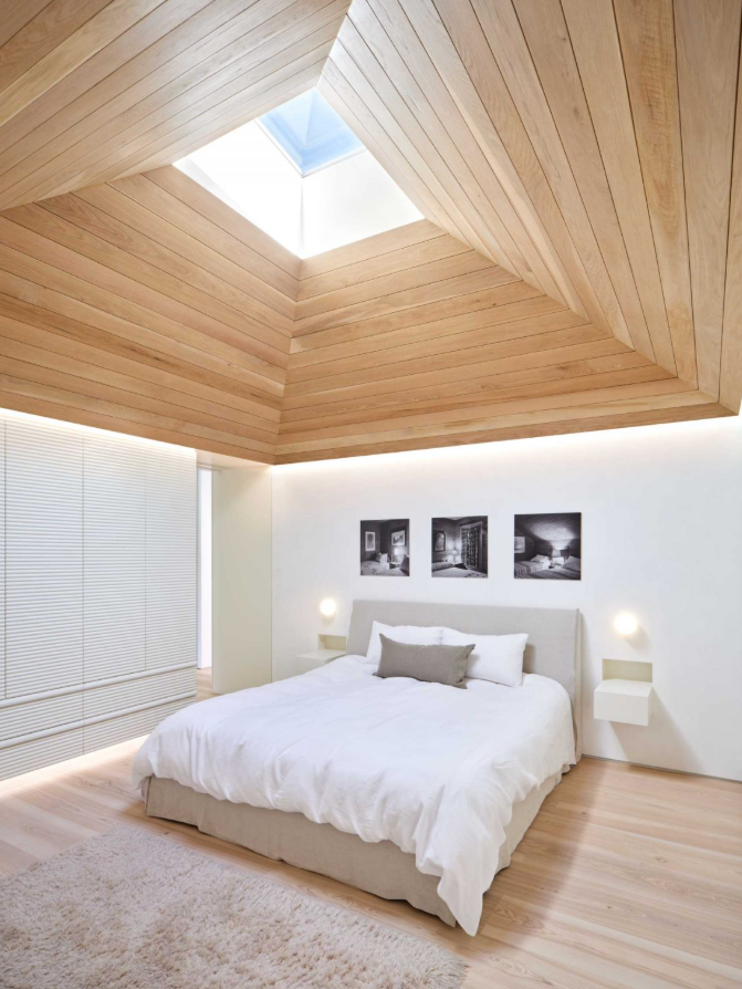 Phòng ngủ chính nổi bật với trần nhà hình vòm bằng gỗ sồi trắng, có cửa sổ mái giúp đón ánh sáng ban mai chiếu xuống không gian. Ảnh: @Aalso Architects, HYCArch.