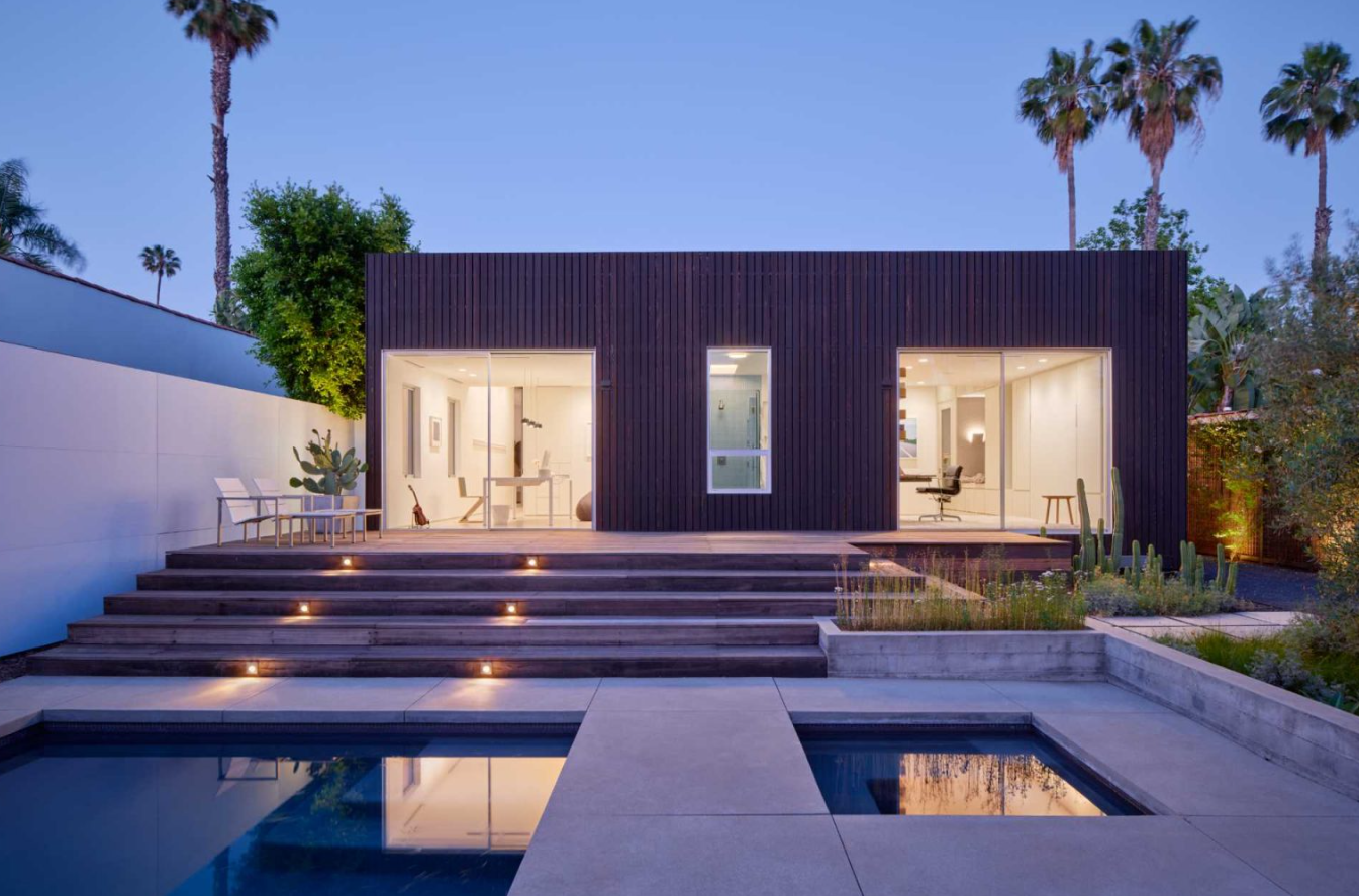 Phía sau nhà là một sàn gỗ có bậc thang dẫn xuống hồ bơi nhỏ và bồn tắm nước nóng. Những chậu cây nhỏ được trồng các loại cây dễ chăm sóc. Ảnh: @Aalso Architects, HYCArch.