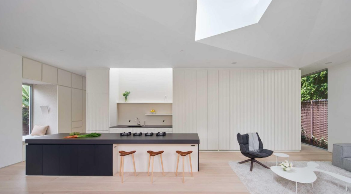 Ngay gần đó, khu bếp có mặt bàn bằng sứ nung Neolith. Ba chiếc ghế đẩu làm từ gỗ phong tạo thêm điểm nhấn tự nhiên. Ảnh: @Aalso Architects, HYCArch.