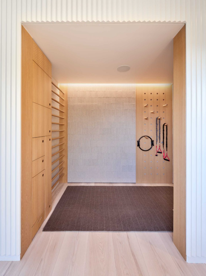 Ngôi nhà còn có một phòng dành cho việc yoga thiền định, được ốp gỗ với những đường gờ mềm mại, che giấu một tủ đựng đồ để chứa các dụng cụ yoga. Ảnh: @Aalso Architects, HYCArch.