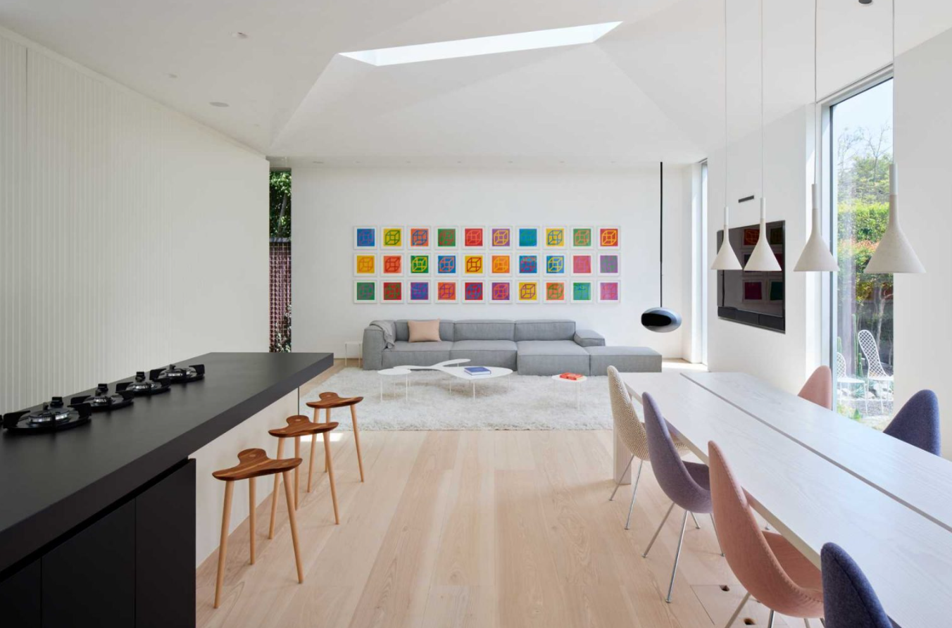 Bước vào bên trong, bạn sẽ thấy một phòng khách rộng rãi, ngập tràn ánh sáng với những tác phẩm nghệ thuật đầy màu sắc của Sol LeWitt và một lò sưởi màu đen hiệu Cocoon Aeris. Ảnh: @Aalso Architects, HYCArch.