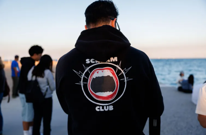 Đồng sáng lập Manny Hernandez mặc áo hoodie của câu lạc bộ la hét trước khi tổ chức buổi gặp mặt lần thứ mười một của câu lạc bộ gần bãi biển North Avenue vào ngày 31 tháng 8 năm 2025. (Armando L. Sanchez/Chicago Tribune)