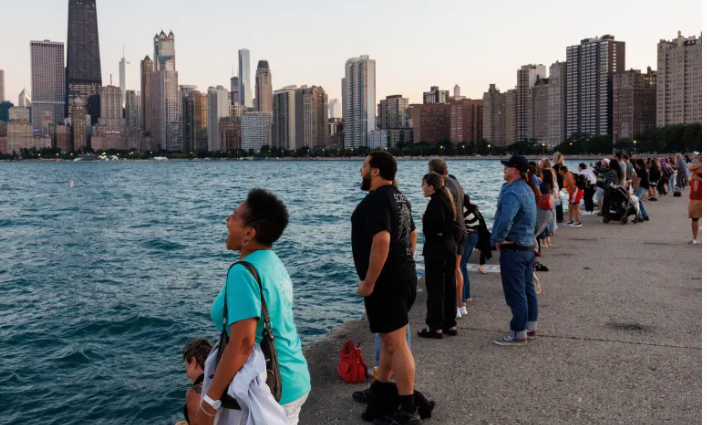 Một nhóm người đứng đối diện với hồ Michigan và la hét trong buổi tụ tập câu lạc bộ la hét lần thứ mười một gần bãi biển North Avenue vào ngày 31 tháng 8 năm 2025, tại Chicago. (Armando L. Sanchez/Chicago Tribune)