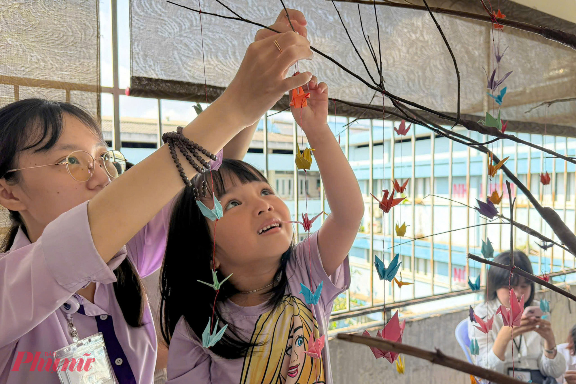 Treo chú hạc lên cây, bé gái (9 tuổi, ngụ phường Gia Định, TP.HCM) khẽ chia sẻ: “Con xếp hạc để ước mơ mau hết bệnh, được trở về nhà”. 