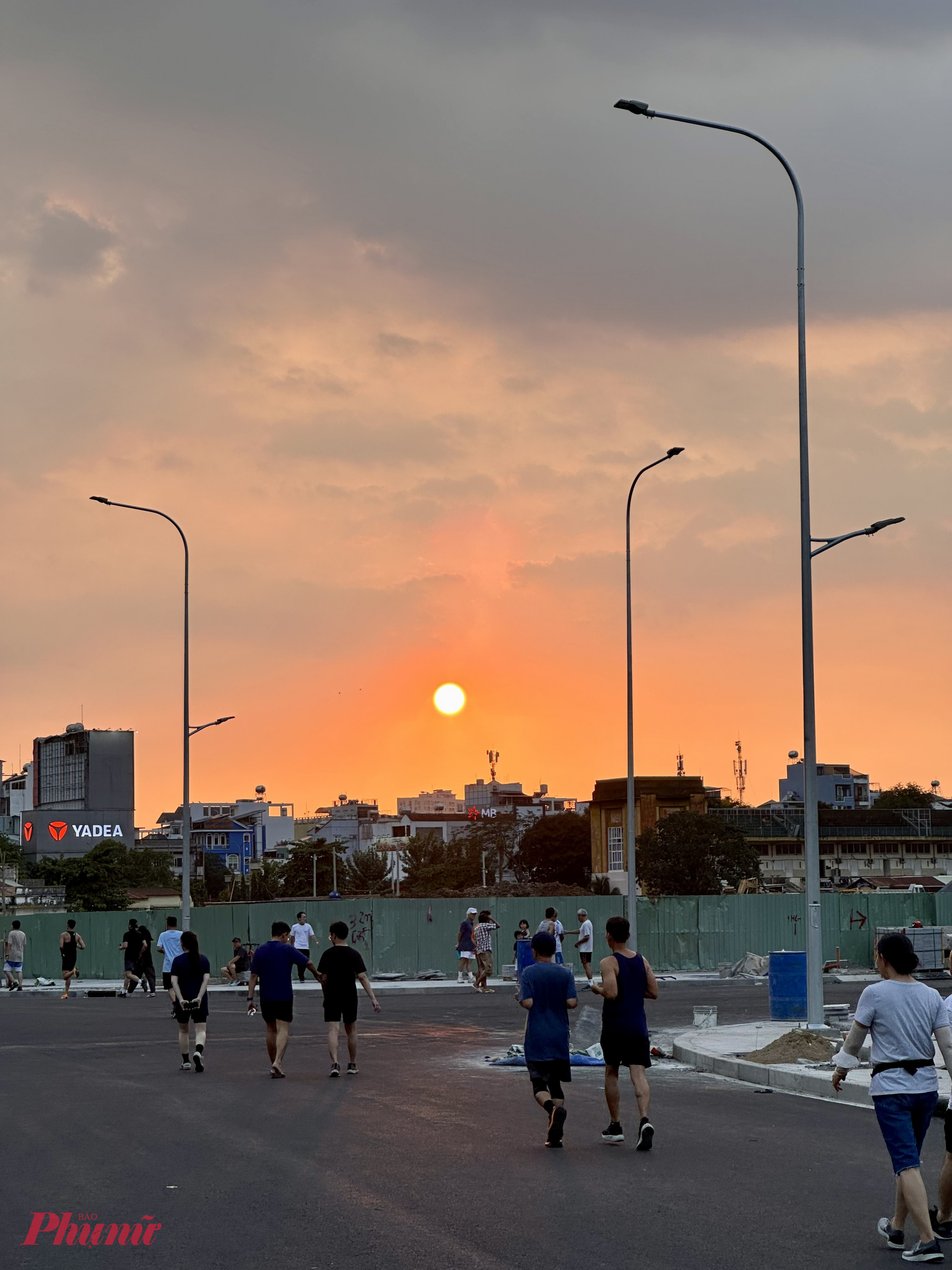 Mặt trời đỏ rực hạ thấp dần sau dãy nhà, nhuộm cả con đường mới thành một buổi chiều rất đỗi bình yên.