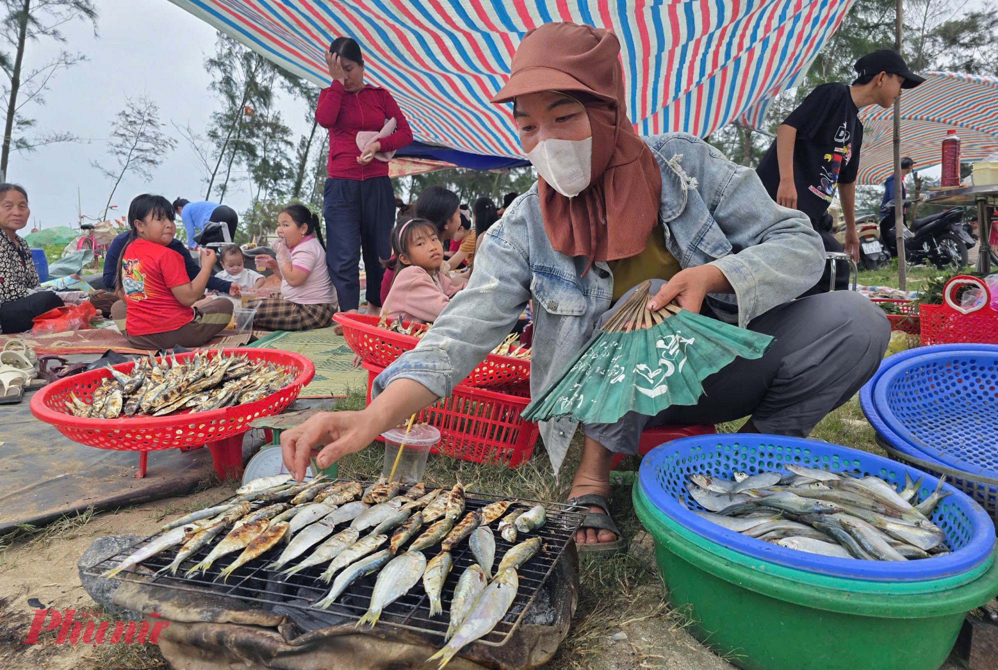 Chỉ với chiếc quạt nan, đôi đũa dài và khung sắt giản đơn, những người phụ nữ làng chài thoăn thoắt xếp cá, trở tay liên tục trên bếp than hồng để kịp phục vụ khách. Lượng người đổ về tăng đột biến, nhất là giới trẻ, khiến họ phải làm việc không ngơi nghỉ, “mỏi tay” vẫn luôn trong tình trạng quá tải.