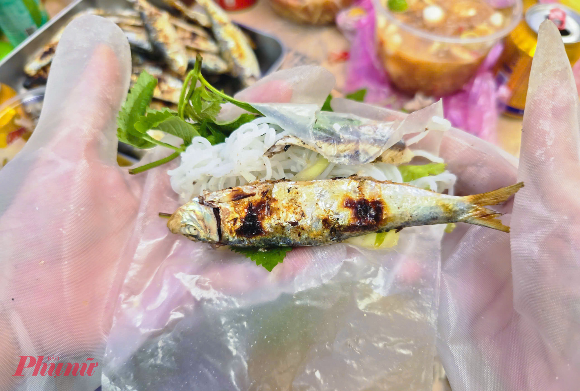 Cá trích nướng tại các điểm ven biển được bán với giá 50.000-60.000 đồng/kg, ăn kèm rau sống, bún, lá nem và nước chấm. Cá vừa nướng xong có vị béo, thơm, bùi, khi cuốn cùng rau tạo cảm giác hài hòa, dễ ăn.