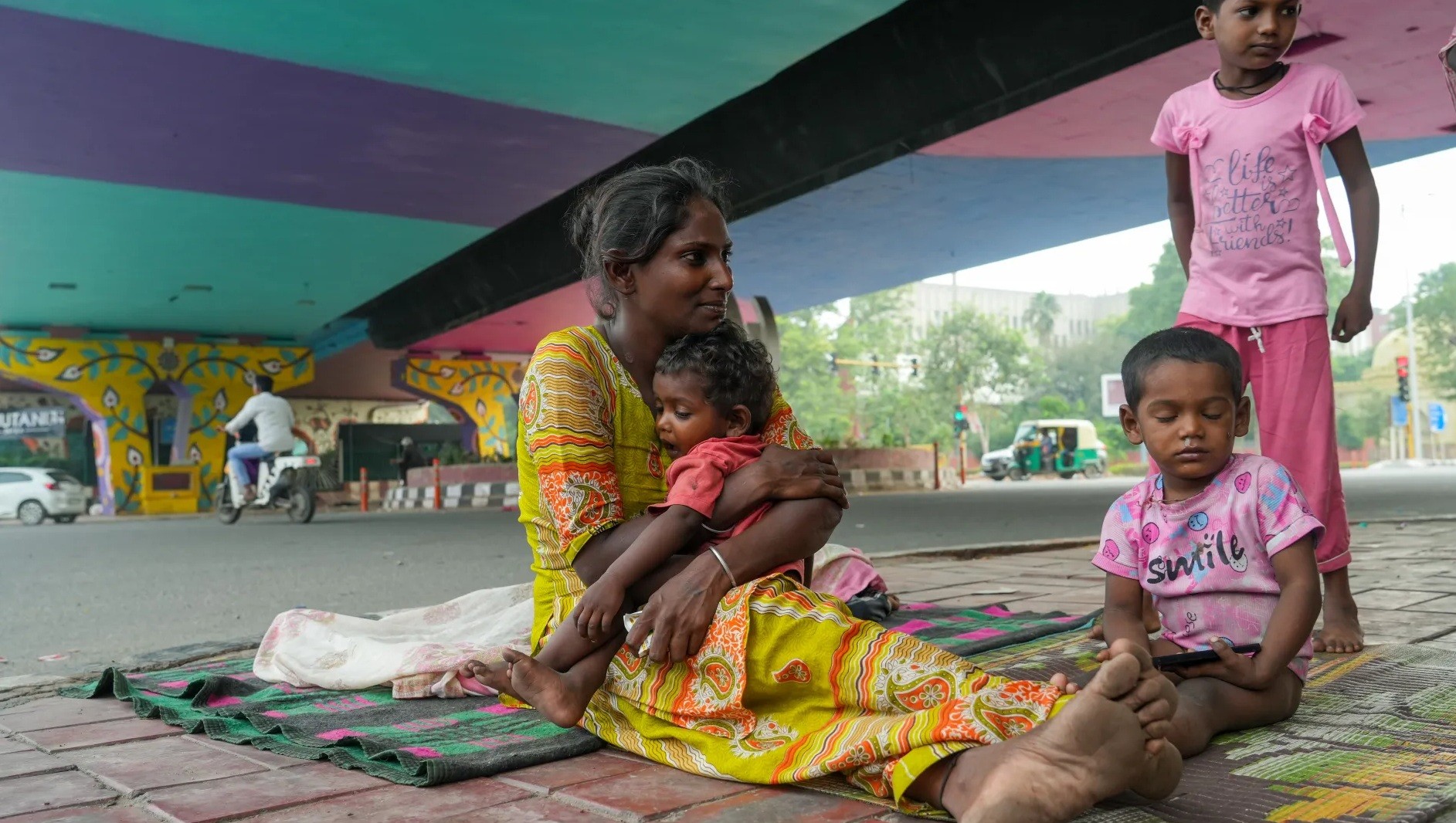 Abida, 40 tuổi, ngồi trên chiếu cùng 3 đứa con dưới gầm cầu vượt ở thành phố Delhi, Ấn Độ - Ảnh: Suhail Bhat/Al Jazeera
