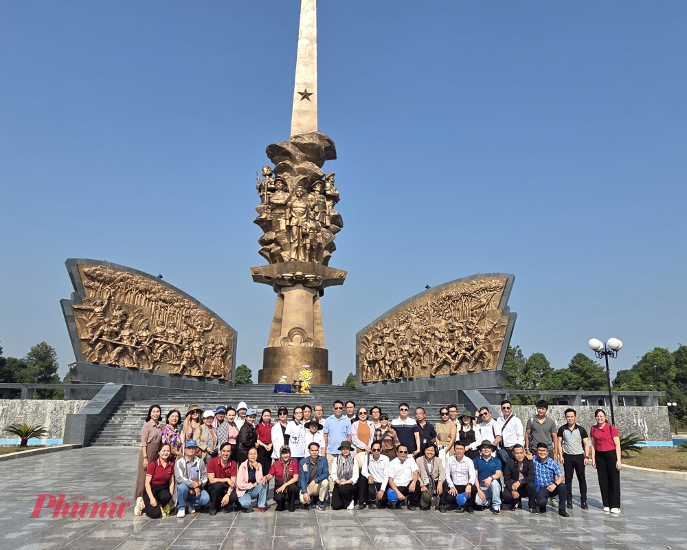 Đoàn chụp ảnh lưu niệm tại tượng đài trung tâm Khu tưởng niệm chiến khu Đ - tượng đài cao 64m lấy cảm hứng từ thanh gươm mở cõi trong thơ Huỳnh Văn Nghệ.