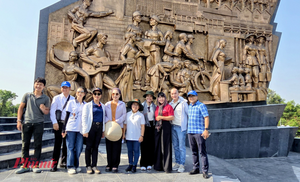 Các nghệ sĩ chụp ảnh lưu niệm tại bức phù điêu ghi công các văn nghệ sĩ trong kháng chiến tại Khu tưởng niệm chiến khu Đ.