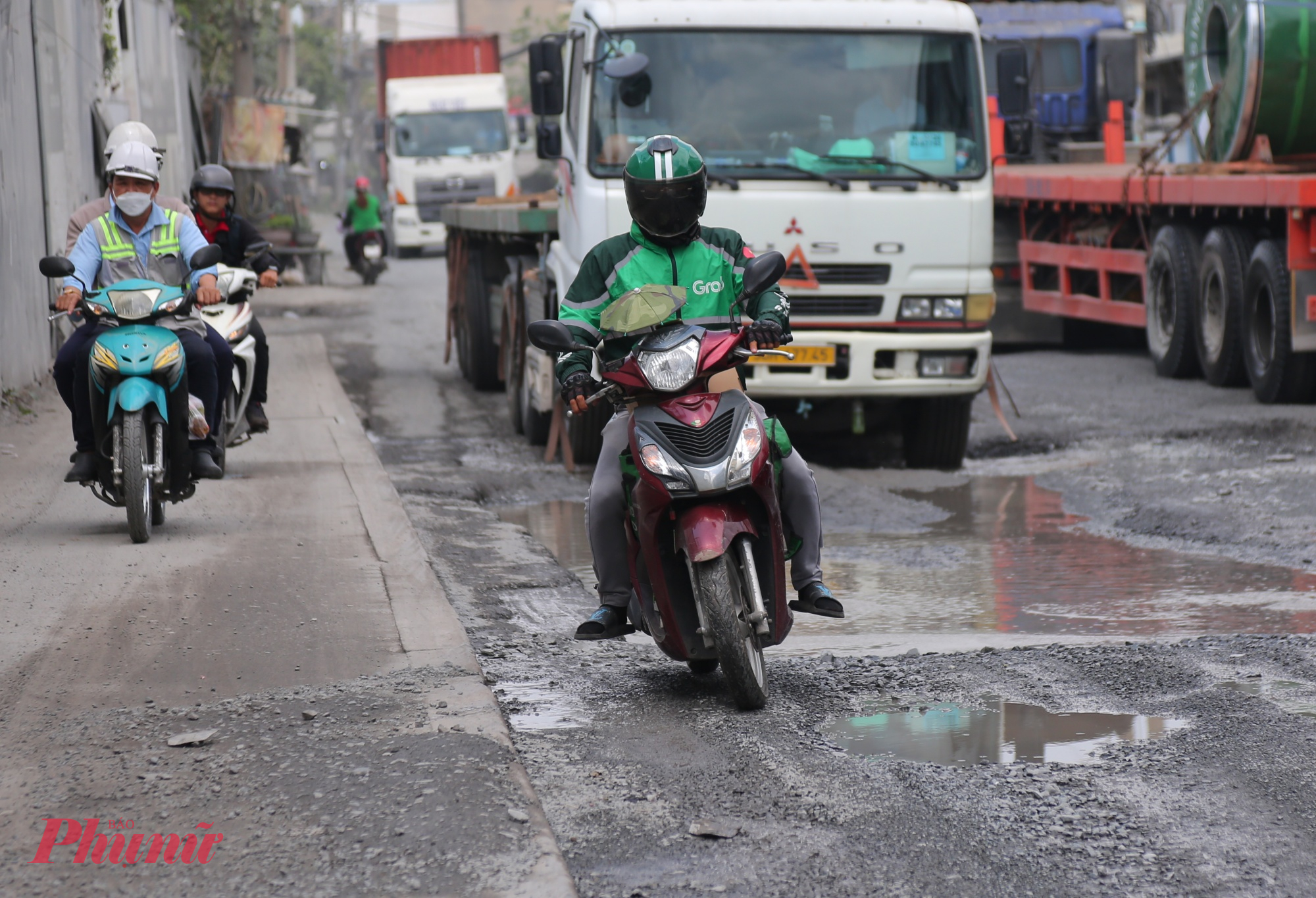 Người đi xe máy cũng gặp nhiều nguy hiểm. Để tránh các hố sâu, nhiều người buộc phải leo lên vỉa hè hoặc đi ngược chiều.