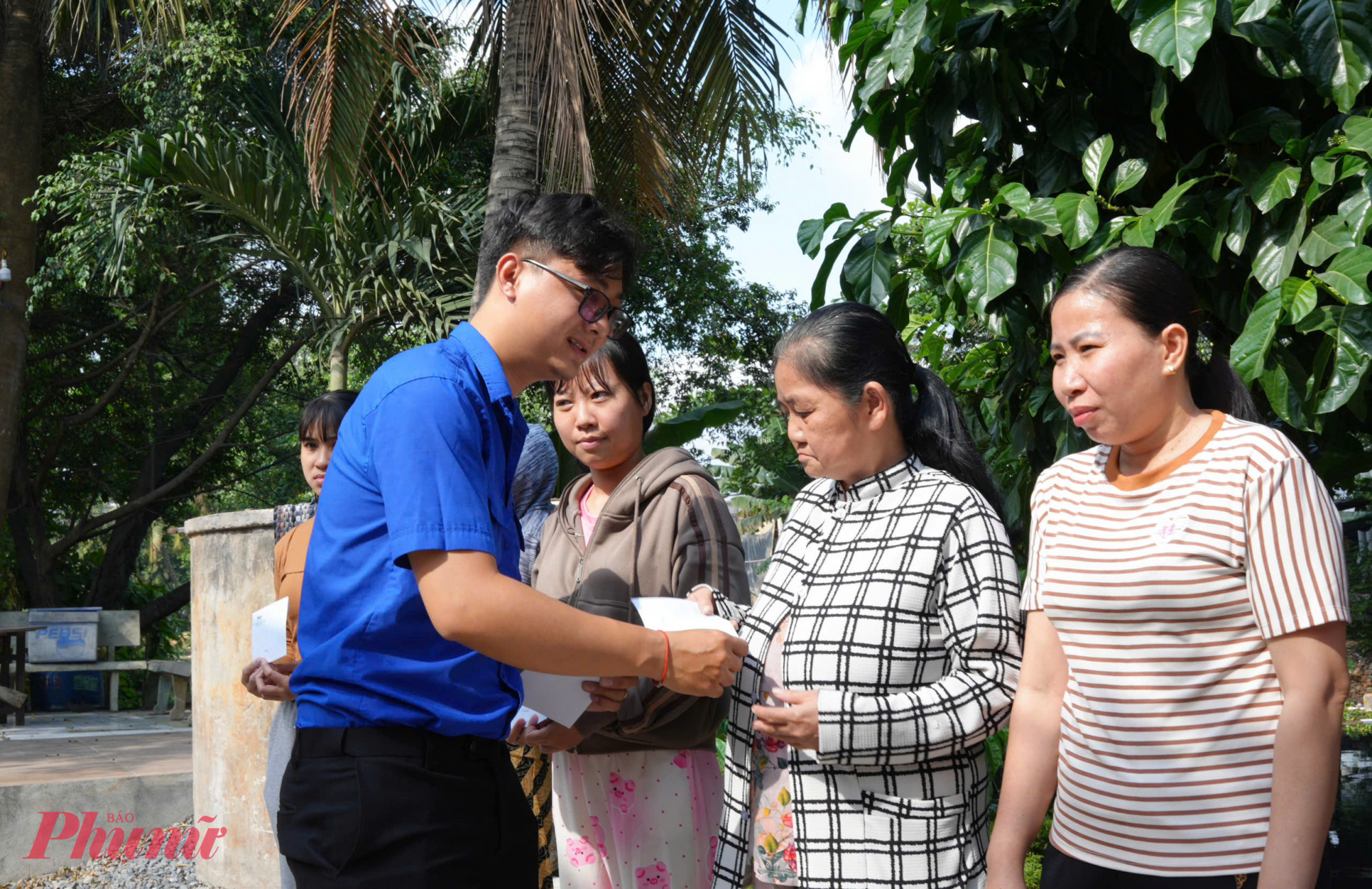 Ông Nguyễn Đình Khoa  - Ủy viên Ban chấp hành Chi đoàn cơ sở Báo Phụ nữ TPHCM trao quà đến phụ nữ khó khăn.