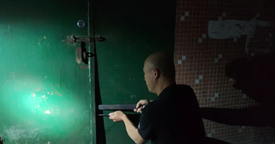 Một sĩ quan cảnh sát buộc mở cổng ở lối vào nhà của người đàn ông bị mắc kẹt. Ảnh: QQ.com