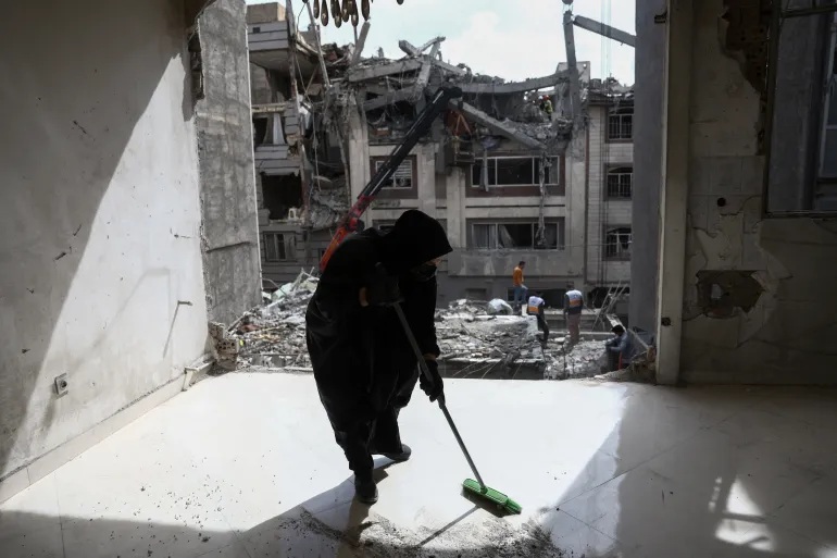 Một tình nguyện viên đang quét dọn bên trong một tòa nhà dân cư bị hư hại do cuộc không kích của Mỹ và Israel ở Tehran, Iran, ngày 28/3 - Ảnh: Majid Asgaripour/West Asia News Agency