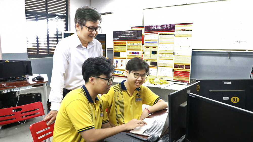 Nhật Bảo (bìa trái) và Tấn Đức bàn luận về dự án cùng thầy hướng dẫn Đỗ Quốc Anh Triết