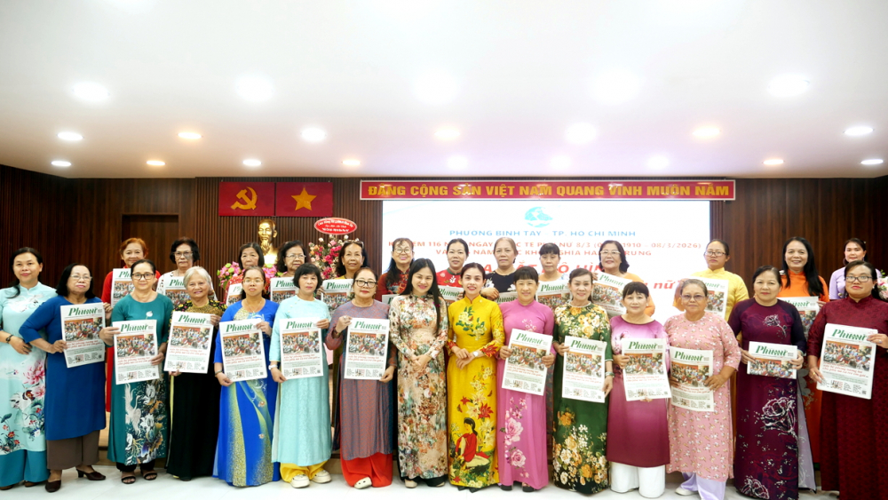 Bà Trần Lê Kim Chi - Phó chủ tịch Ủy ban MTTQ Việt Nam phường, Chủ tịch Hội LHPN phường Bình Tây và bà Phạm Thị Vân Anh - Phó tổng biên tập Báo Phụ nữ TPHCM (thứ bảy và thứ tám từ trái qua) - gửi tặng báo đến các chi hội tại lễ ra mắt mô hình “Mỗi chi hội - Một tờ báo Phụ Nữ” ngày 6/3 - ẢNH: DIỄM TRANG