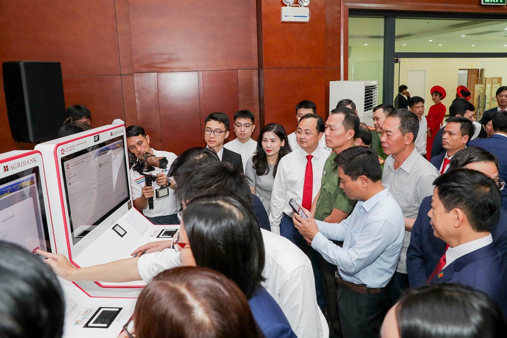 Ông Tô Huy Vũ - Chủ tịch HĐTV Agribank cùng đại biểu tham gia tra nghiệm mô hình thí điểm Kiosk thông minh và Hệ thống xác thực, cấp bản sao số tài liệu điện tử - Ảnh: Agribank
