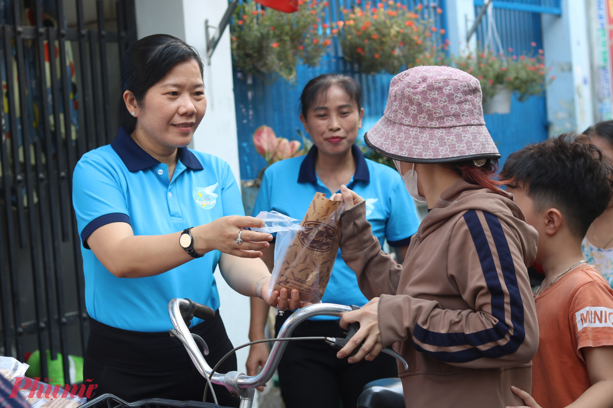 Bà Phạm Thị Mộng Hằng – Phó chủ tịch thường trực Ủy ban MTTQ Việt Nam phường Tân Thới Hiệp, Chủ tịch Hội LHPN phường – tặng bánh mì các bà, các chị trong ngày 31/3 - Ảnh: Mẫn Nhi