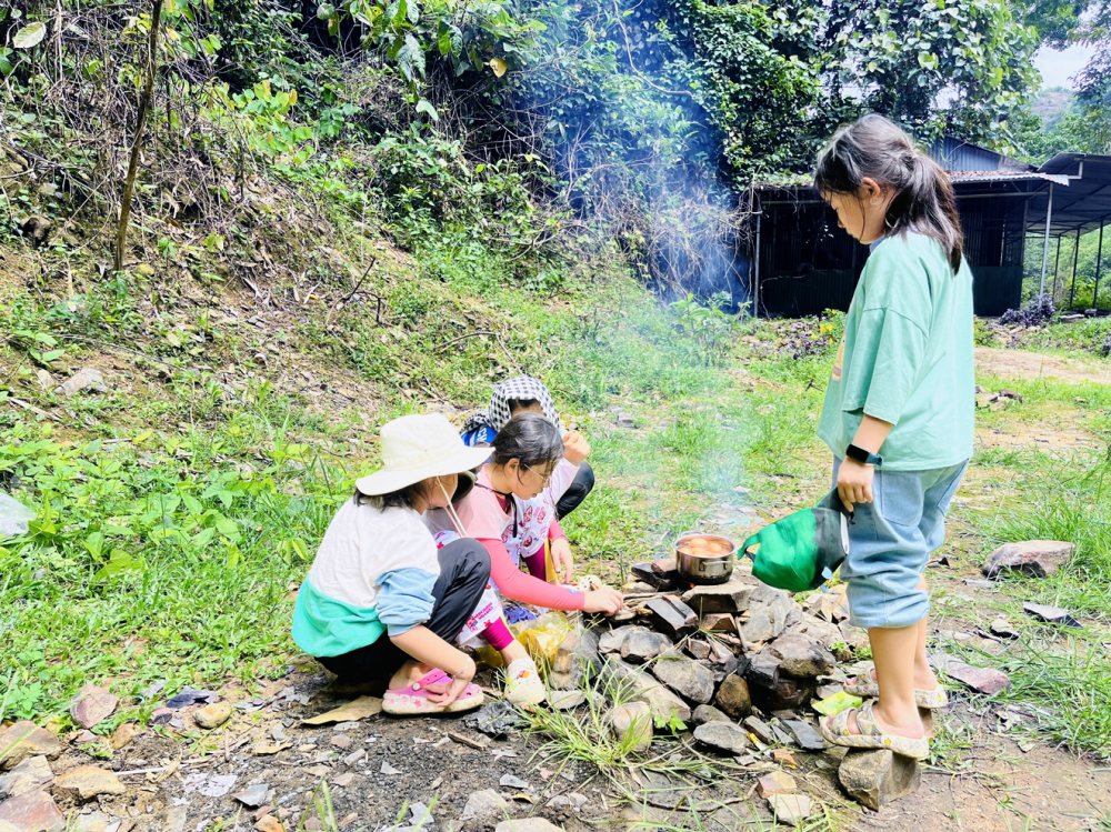 Các em nhỏ học cách nhóm lửa, nấu ăn tại trại hè - Nguồn ảnh: Alpha Camp