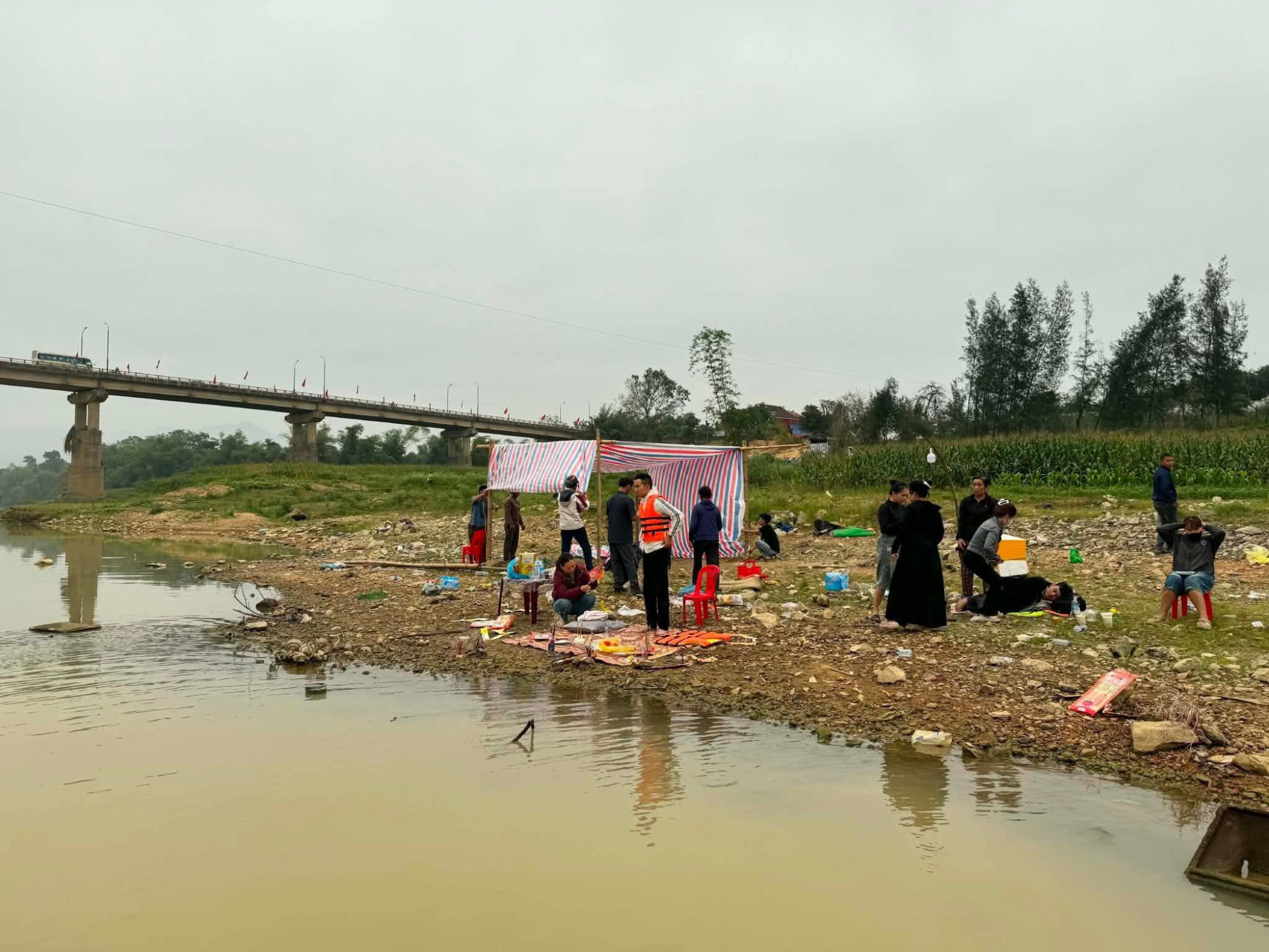 Người thân dựng lều bên bờ sông ngóng tin từ các lực lượng chức năng đang tìm kiếm nạn nhân - Ảnh: Ngọc Anh