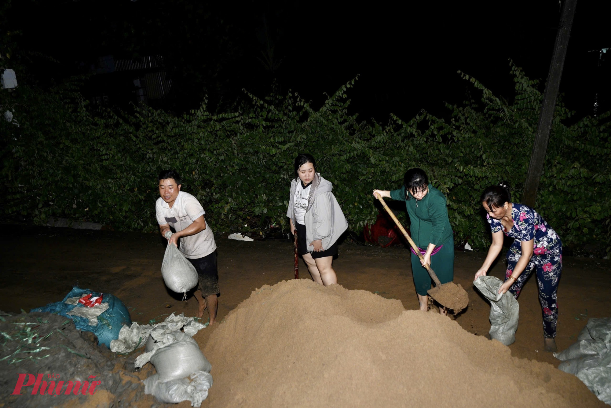Người dân đắp bao cát và gia cố bờ kênh dọc đường Bình Quới (phường Bình Quới, TPHCM) nhằm ngăn triều cường tràn vào khu dân cư, hạn chế nguy cơ sạt lở và sập bờ kè - Ảnh: Thanh Tâm