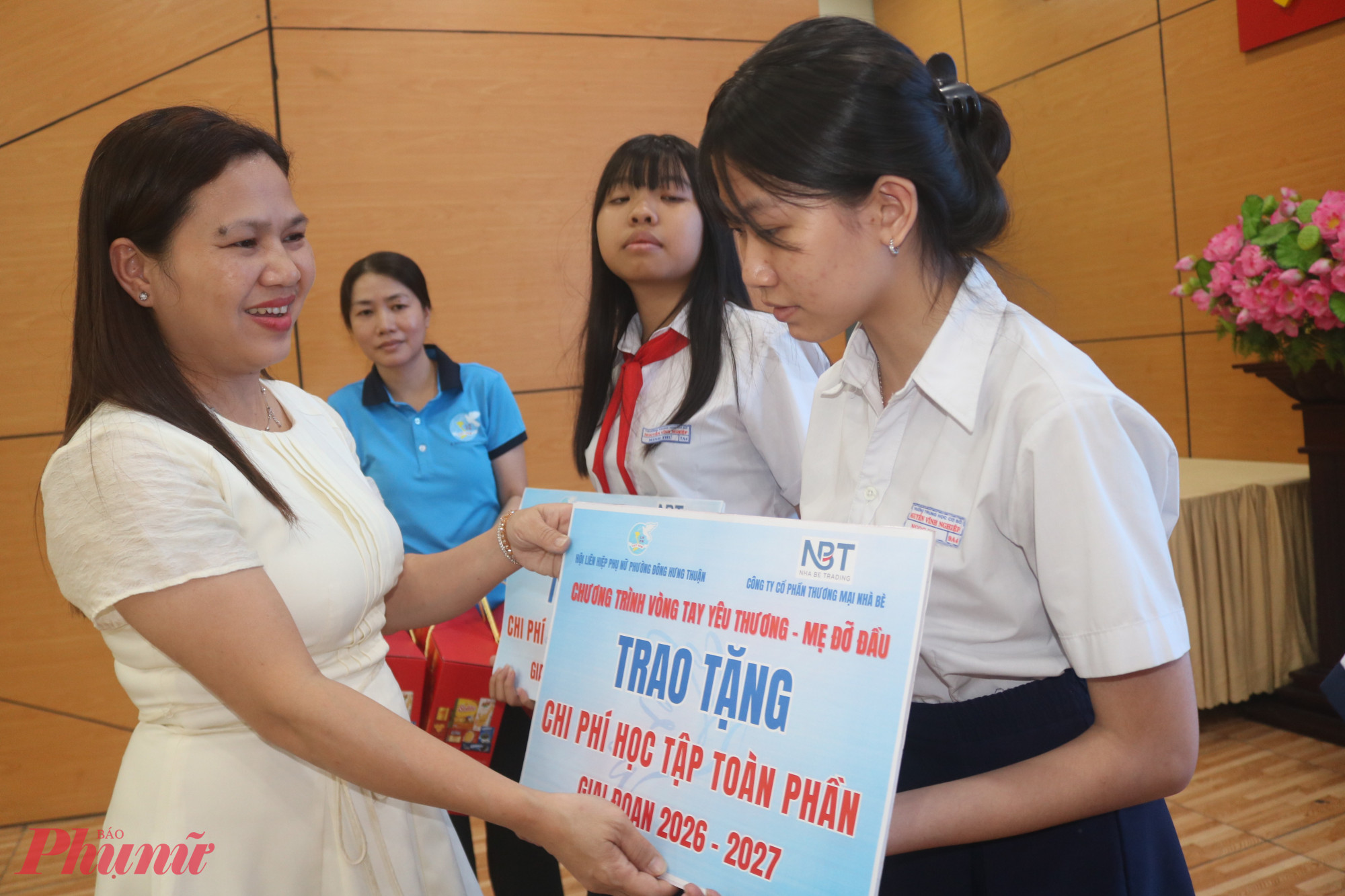 Bà Trần Thị Ngọc Điệp – Phó giám đốc Công ty cổ phần thương mại Nhà Bè – trao bảng tượng trưng hỗ trợ chi phí học tập toàn phần giai đoạn 2026 – 2027 cho các em học sinh - Ảnh: Mẫn Nhi