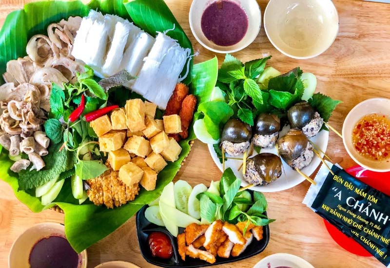 Bún đậu mắm tôm vốn xuất phát từ những nguyên liệu giản dị như bún lá, đậu hũ chiên và rau sống, được bày trên mẹt tre, tạo nên nét mộc mạc đặc trưng của ẩm thực Bắc. Theo thời gian, để phù hợp khẩu vị đa dạng, món ăn được biến tấu phong phú hơn với dồi sụn, thịt luộc, chả mực hay nem rán.