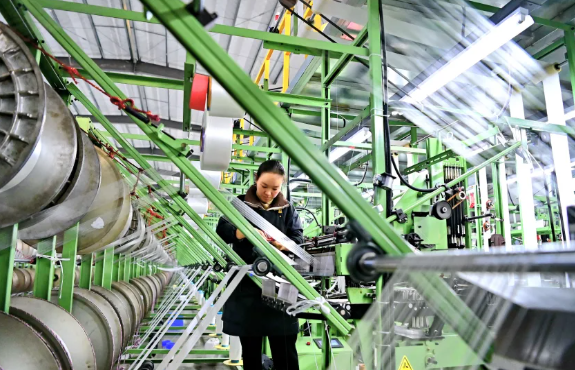 Một nhân viên làm việc tại xưởng kéo sợi của một nhà máy sợi polyester ở Cửu Giang, Trung Quốc, vào ngày 16 tháng 1 năm 2024. Hình ảnh Zhu Haipeng / VCG / Getty