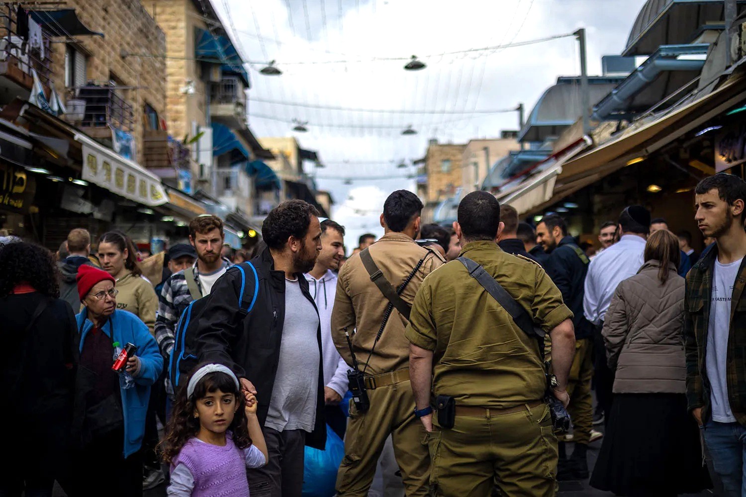 Các binh sĩ vũ trang đi lại giữa những người mua sắm tại chợ Machane Yehuda ở Jerusalem, Israel vào năm 2024 - Ảnh: Yahel Gazit/Middle East Images/Getty Images