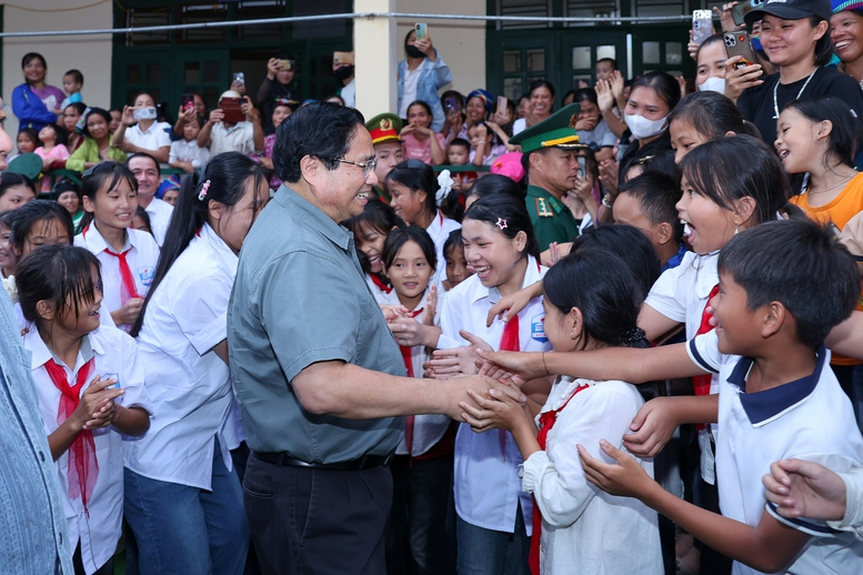 Thủ tướng Phạm Minh Chính và các em học sinh tại lễ khởi công trường nội trú liên cấp tiểu học – trung học cơ sở tại xã miền núi Bát Mọt, cách trung tâm tỉnh Thanh Hóa khoảng 120 km về phía tây - Ảnh: VGP/Nhật Bắc