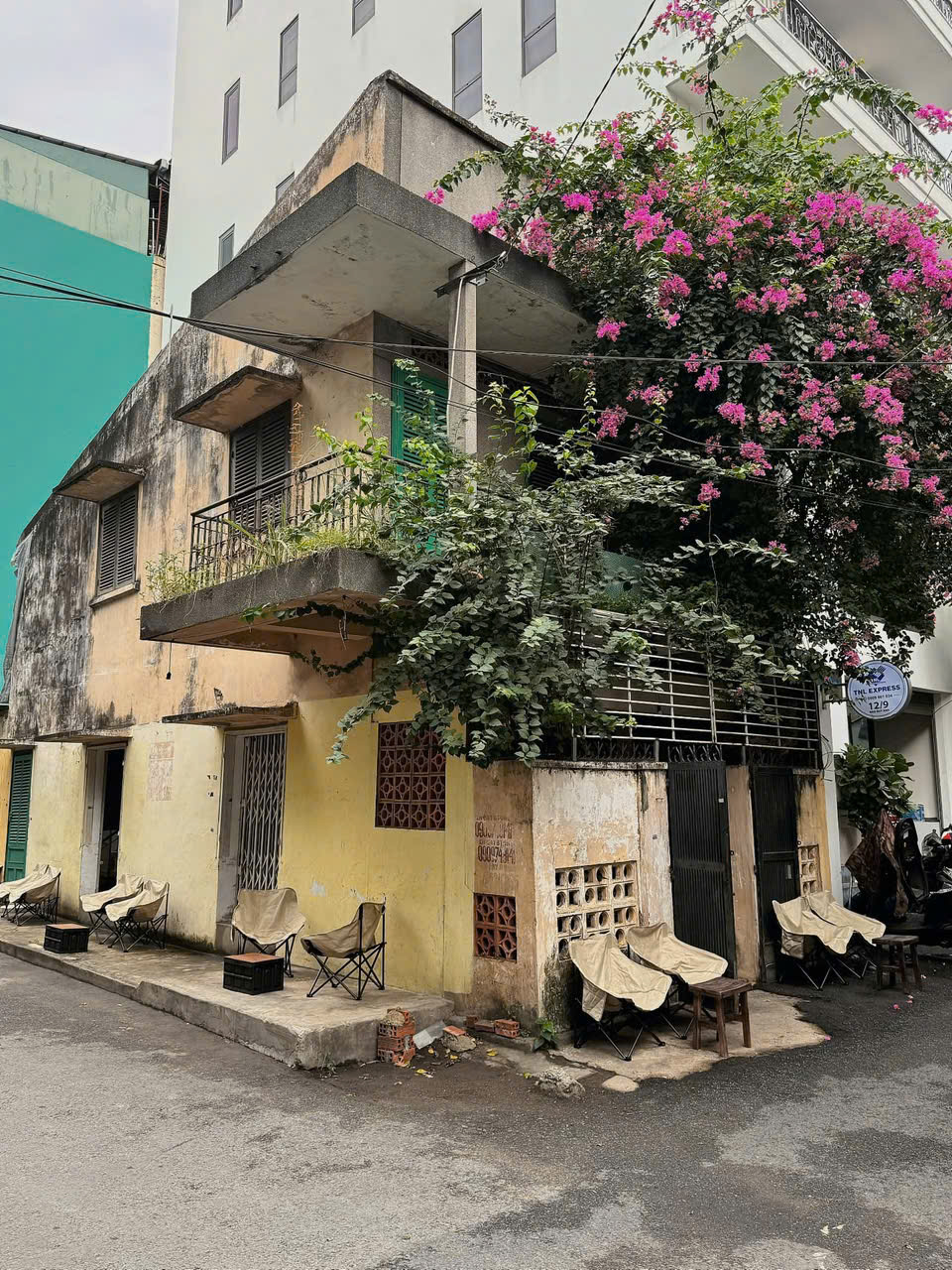 12/7 Đào Duy Anh, Phường Đức Nhuận. Ẩn mình tại con hẻm 12/7 Đào Duy Anh, phường Đức Nhuận, không gian nơi đây mang đậm dấu ấn của một Sài Gòn xưa cũ mà không phải nơi nào cũng còn giữ được. Những ngôi nhà cổ kính với lớp tường nhuốm màu thời gian, ban công sắt uốn cong và ô cửa gỗ giản dị tạo nên một bức tranh trầm mặc nhưng đầy cuốn hút. Con hẻm không quá rộng, vừa đủ để ánh nắng len lỏi qua từng khoảng tường, đổ xuống những vệt sáng vàng ấm áp, khiến mọi góc nhỏ đều có thể trở thành một khung hình đầy chất thơ. Xen kẽ trong đó là những quán cà phê nhỏ xinh, mang phong cách hoài niệm, nơi người ta dễ dàng tìm thấy một chỗ ngồi yên tĩnh để “chill”, nhâm nhi ly cà phê và chậm rãi cảm nhận nhịp sống nhẹ nhàng, rất khác với sự ồn ào thường nhật của thành phố.