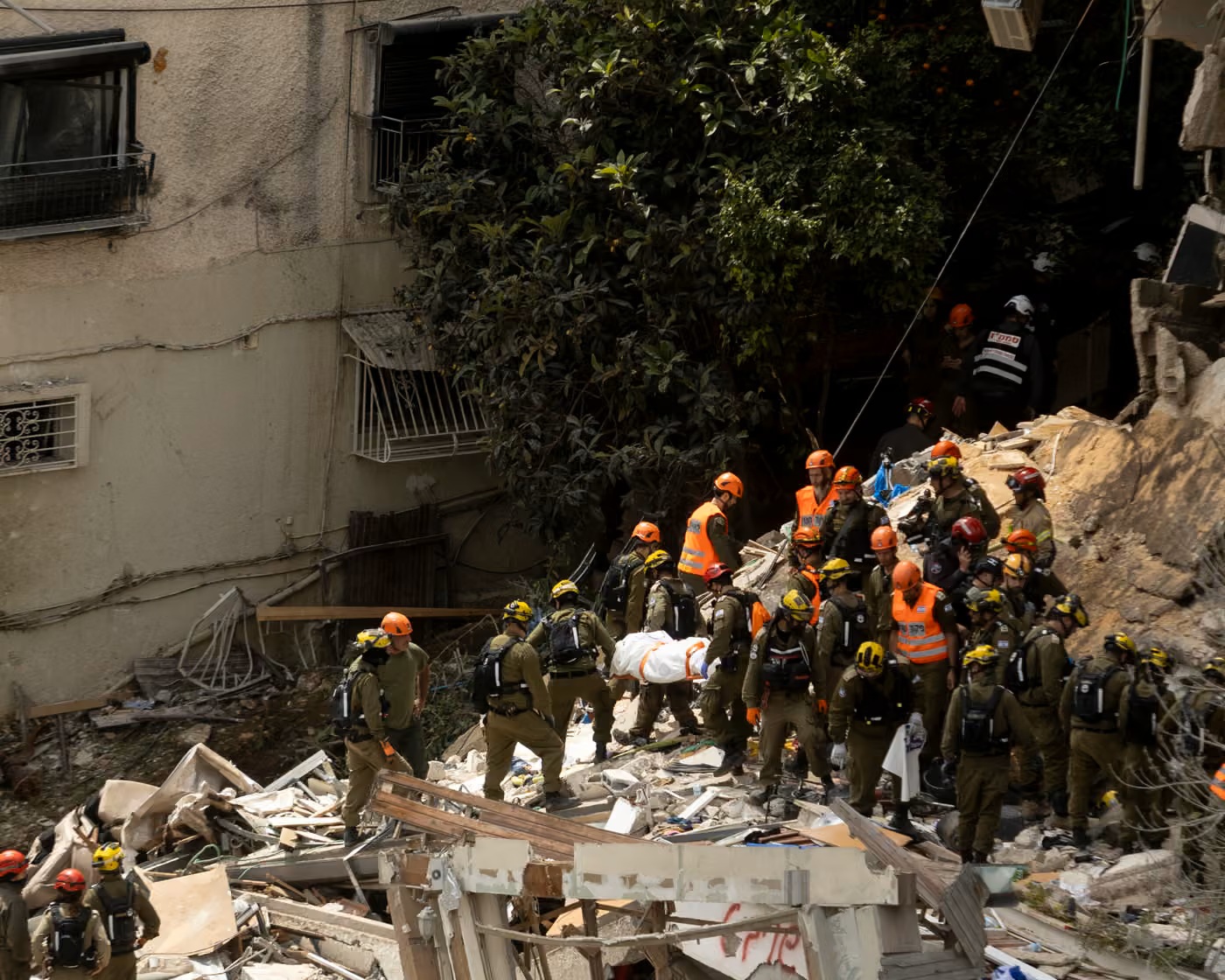 Lực lượng cứu hộ Israel khiêng một nạn nhân ra khỏi tòa nhà dân cư sau vụ tấn công bằng tên lửa đạn đạo của Iran ở thành phố Haifa - Ảnh: Amir Levy/Getty Images