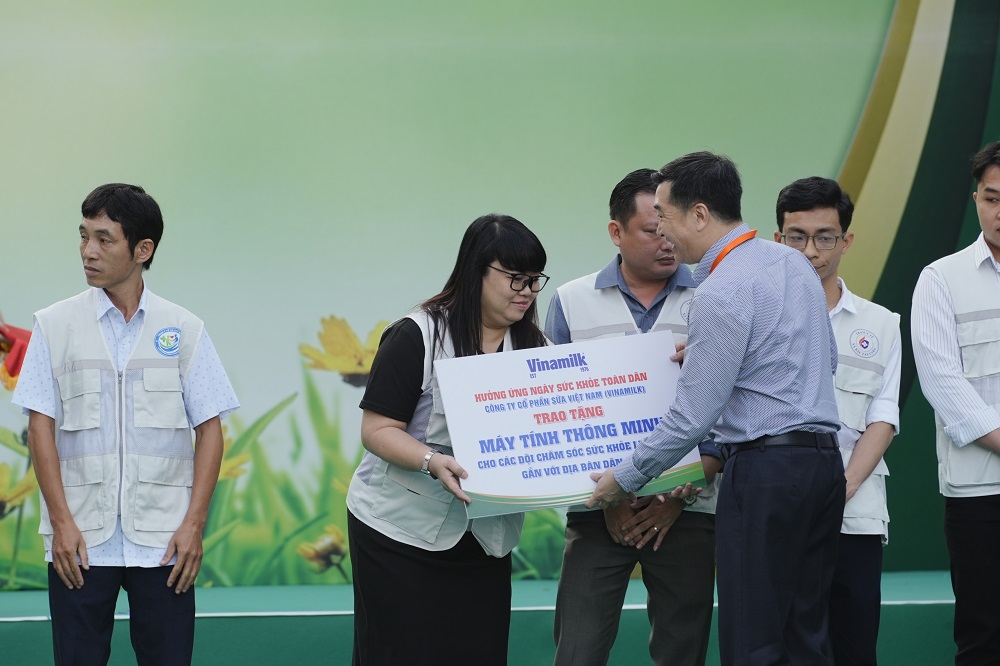 Đại diện Vinamilk, ông Đỗ Thanh Tuấn - Giám đốc Đối ngoại - trao bảng tượng trưng máy tính thông minh đến đại diện các “Đội chăm sóc sức khỏe liên tục gắn với địa bàn dân cư” - Ảnh: VN