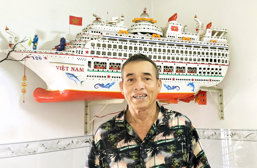 Ông Nguyễn Xết bên mô hình tàu biển đặt trong nhà mình