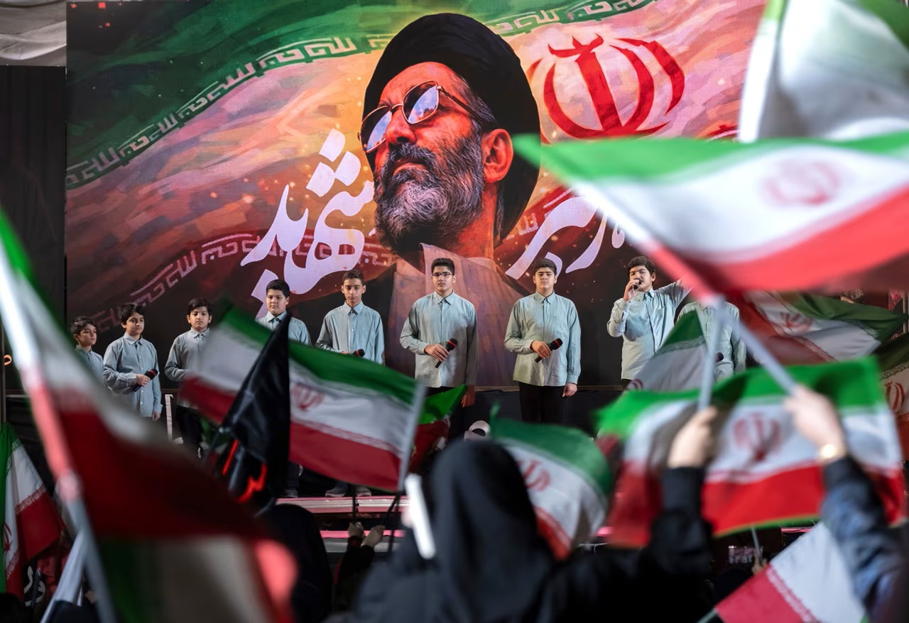 Một nhóm thanh niên Iran biểu diễn dưới bức chân dung của cố lãnh đạo tối cao Iran Ayatollah Ali Khamenei trong uộc biểu tình ủng hộ chính phủ ở trung tâm Tehran ngày 4/6 - Ảnh: Morteza Nikoubazl/NurPhoto/Shutterstock