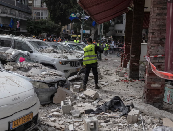 Các công nhân thành phố dọn dẹp đường phố tại một tòa nhà bị trúng đạn của Iran ở Ramat Gan, miền trung Israel. Ảnh: Ilia Yefimovich / AFP / Getty Images